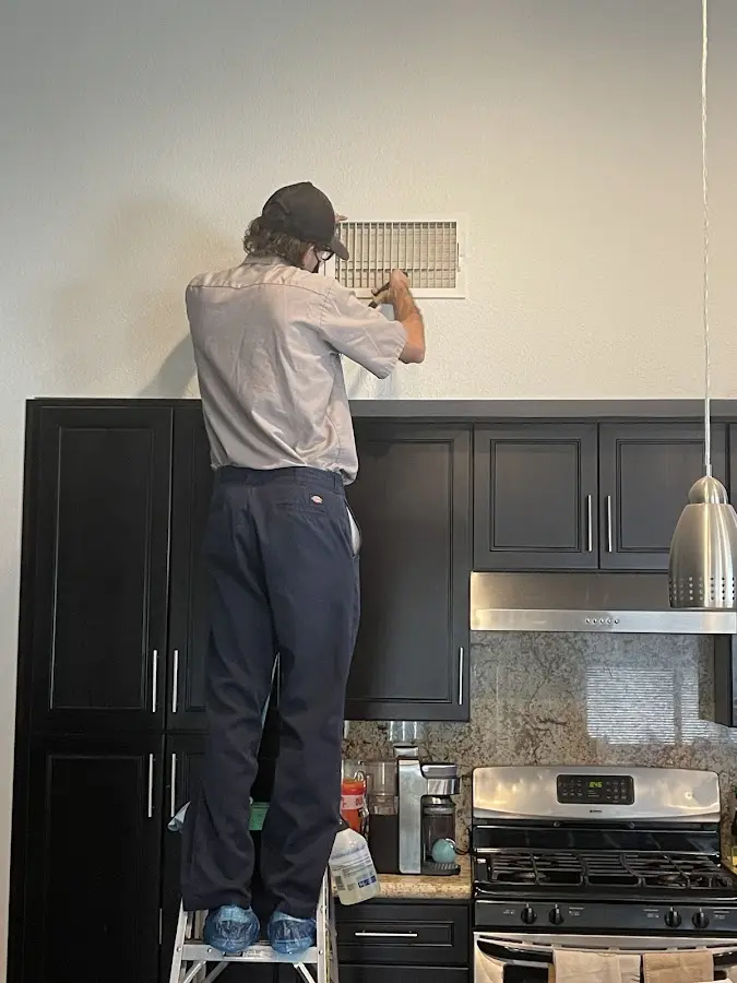 Technician inspecting an air vent during HVAC service in Cranford